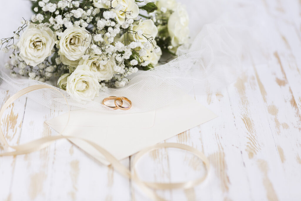 high-angle-engagement-rings-beside-flowers